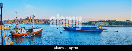 Sliema lungomare si apre una vista su navi e imbarcazioni, medievale Valletta skyline con alto campanile di San Paolo Pro-Cathedral anglicana e dome Foto Stock