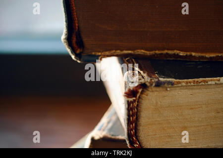 Alcune vecchie multi-page libri, ingiallito dal tempo, giacciono in un palo, illuminata dal sole. Foto Stock