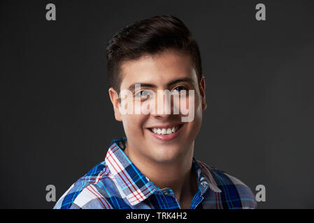 Allegro sorridente giovane nel buio di sfondo per studio Foto Stock