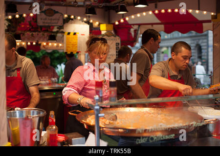 I cuochi preparano pasti om bavarese tradizionale mercato alimentare Foto Stock