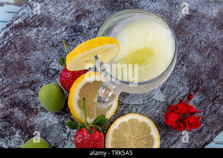 La limonata con ghiaccio. Limonata Fresca con fragola e menta shot top giù sul tavolo rustico. Foto Stock