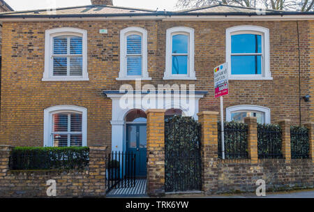 Una coppia di periodo, costruiti in mattoni, case a schiera, di fronte a una strada principale di Chiswick, West London, England, Regno Unito. Foto Stock