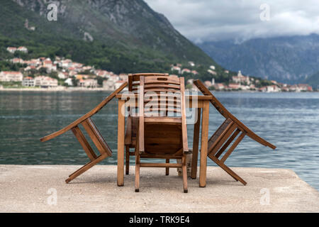 Dobrota, Montenegro - tavolo e sedie a sdraio sulla terrazza sul mare dopo la pioggia a molla Foto Stock