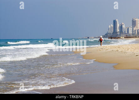 Spiaggia di Tel Aviv, Israele. Onde da surf, distante a piedi la figura Foto Stock