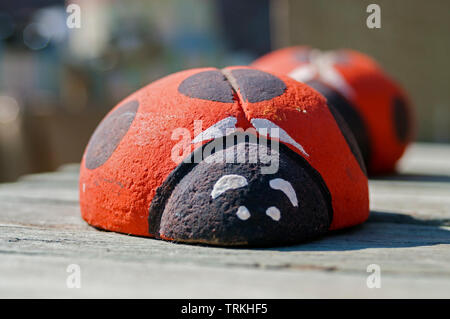 Bello e colorato stone ladybugs appoggiato su un tavolo in un mercato in una giornata di sole Foto Stock