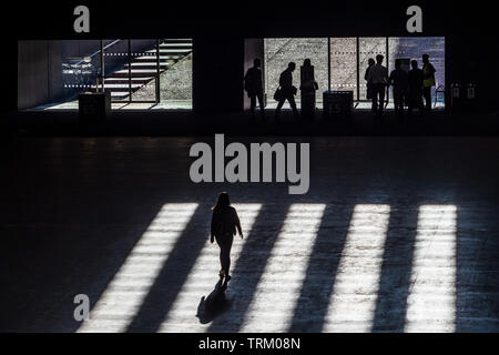 Tate Modern Art Gallery - ombre cadono sul popolo in cammino verso la galleria uscire Foto Stock