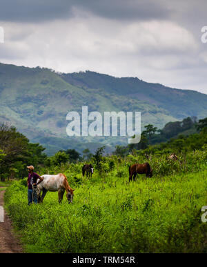 Latin rancher parlando per gli escursionisti in campagna in Guatemala Foto Stock