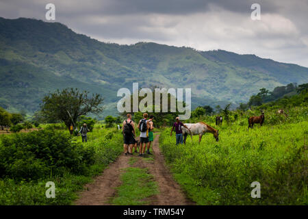 Latin rancher parlando per gli escursionisti in campagna in Guatemala Foto Stock