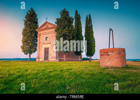 Fotografia popolare e località turistiche in Toscana, incredibile Cappella di Vitaleta e antica pietra acqua bene al tramonto colorato, Pienza, Toscana, Italia, UE Foto Stock