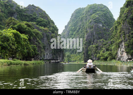 Attività a valle sulla barca con il vietnamita con piedi racchetta e vista montagna calcarea in Ngo Dong river, Ninh Binh, Halong Bay a terra Foto Stock