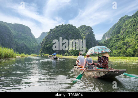 Attività a valle nella valle di montagna sulla barca con il vietnamita con piede pala in Ngo Dong river, Ninh Binh, Halong Bay a terra Foto Stock