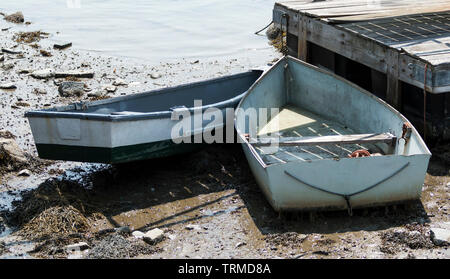 La bassa marea nel Maine lascia due piccole barche a remi nel fango e fuori o l'acqua. Foto Stock