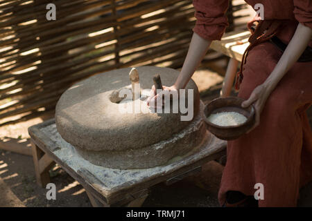 Donna macina grano e farina fa su macina Foto Stock