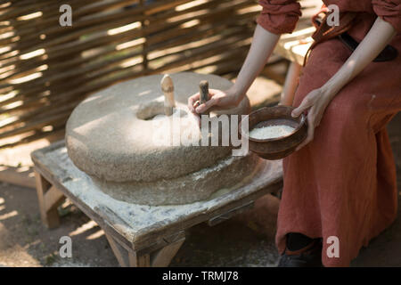 Donna macina grano e farina fa su macina Foto Stock