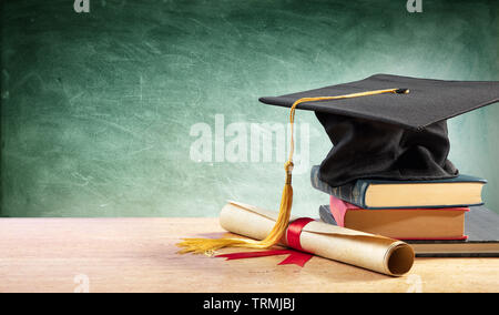 Tappo di graduazione e Diploma sul tavolo con libri Foto Stock