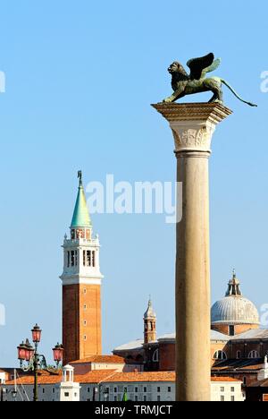 La colonna del leone in piazza San Marco con la chiesa di San Giorgio Maggiore in background, Venezia Italia Europa UE Foto Stock