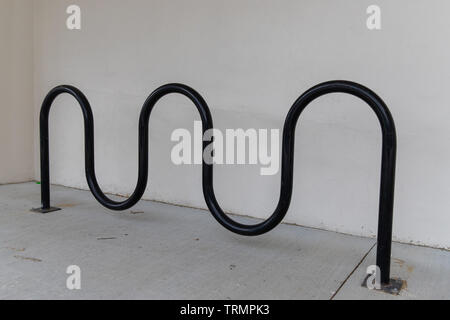 Curva vuota-bici accanto a un edificio bianco Foto Stock