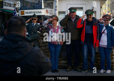 Un gruppo di turisti sono fotografati a una attrazione turistica dove il Checkpoint Charlie utilizzato per essere. Foto Stock