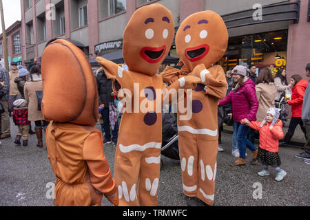 Vancouver, BC, Canada - 11/25/18: Panpepato costume la gente ballare e agendo su una strada di città, durante Yaletown CandyTown a Natale. Foto Stock