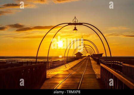 Southport, Merseyside, Regno Unito. Il 9 giugno 2019. Un bel tramonto si accoccola in letto dietro gli archi che attraversano il famoso molo a Southport nel Merseyside. Southport Pier è un piacere pier a Southport, Merseyside England. Inaugurato nel mese di agosto 1860, è il più antico molo di ferro nel paese. La sua lunghezza di 1.108 m rende la seconda più lunga in Gran Bretagna. Credito: Cernan Elias/Alamy Live News Foto Stock