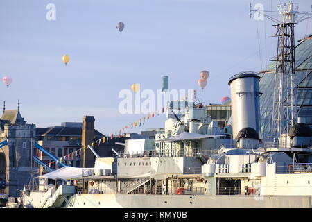 Il floatilla dalla Ricoh Sindaco di Londra la Mongolfiera Regatta 2019 passa sopra il dispositivo HMS Belfast e il Tower Bridge durante le prime ore del mattino. Foto Stock