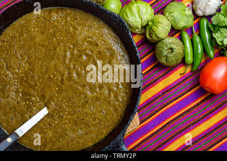 La cucina Messicana salsa verde, salsa verde, fatta con tomatillos, pomodori, cipolle, aglio chiles e coriandolo. Sizzling pan e la cottura a vapore di verdure, co Foto Stock