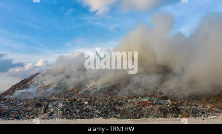 Vista aerea discarica rifiuti mentre bruciano rifiuti con fumo Foto Stock