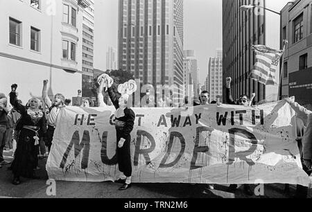 I manifestanti di Dan White frase nell'assassinio del sindaco George Moscone e gay supervisore, Harvey Milk, marzo con pugni sollevata e portano "Egli ha preso il via con l' omicidio' banner, a San Francisco, 1970s Foto Stock