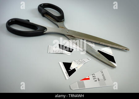 Forbici e pezzi di carta di credito.uscire del debito. Foto Stock
