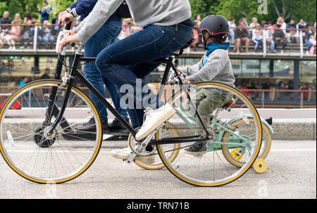 Una famiglia su una bicicletta pedali di una bici, preferendo attivo un sano stile di vita utilizzando il ciclismo e l'alternativa ecocompatibile modalità di trasporto Foto Stock