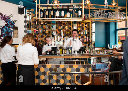 Doncaster, Regno Unito - 11 Maggio 2019: barman e cameriere condividere uno scherzo durante la lucidatura di bicchieri a La Boca ristorante & steakhouse, 1 strada Netherhall Foto Stock