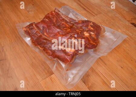 Chiudere la vista delle materie marinata di costolette di maiale in una plastica sacco a vuoto Foto Stock