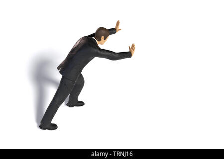 Giocattolo imprenditore in miniatura spingendo, statuetta concetto isolato con ombra su sfondo bianco Foto Stock