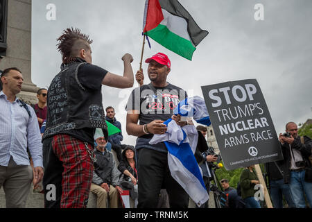 Un LGBT anti-Trump(L) attivista e un pro-Trump(C) sostenitore rabbiosamente dibattito in Trafalgar Square durante le proteste di massa contro il presidente statunitense Donald Trump's UK visita di stato. Foto Stock