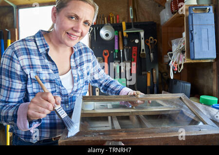 Ritratto di donna matura Upcycling mobili in officina a casa armadio dipinto Foto Stock