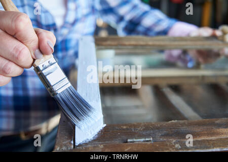 Close up donna Upcycling mobili in officina a casa armadio dipinto Foto Stock