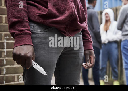 Chiusura del ragazzo adolescente in pista urbano tenendo il coltello Foto Stock