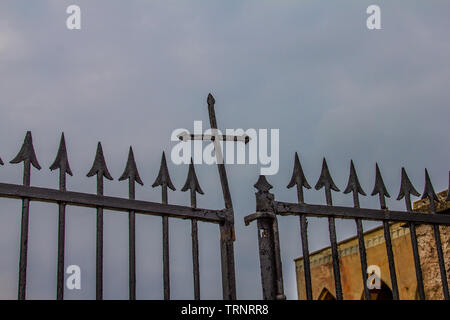 Ferro battuto croce piegata sopra la porta di ingresso del cimitero di Reggio Emilia Italia Foto Stock