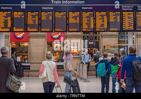 Un sistema elettronico di bacheca presso la stazione ferroviaria di York dando tempi di treno Partenze e arrivi Passeggeri verificare orari. Foto Stock