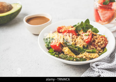 Insalata verde con la quinoa, avocado e gli asparagi in una ciotola bianco. Cibo Vegan concetto. Foto Stock