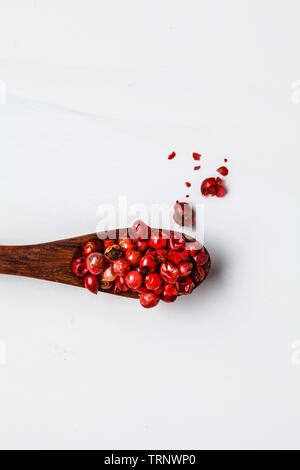 Piselli rosso paprika sul cucchiaio di legno, sfondo bianco. Foto Stock