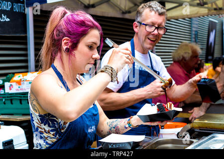 Donna che serve le cialde con condimenti alla Waffle su, Maltby Street Market, London, Regno Unito Foto Stock