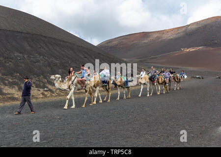 I turisti in una corsa in cammello nel Parco Nazionale di Timanfaya, LAnzerote. Foto Stock