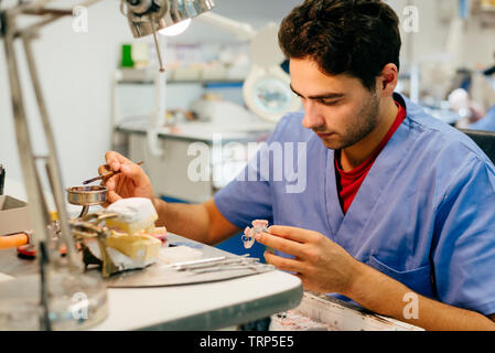 Uomo caucasico lavorando su una protesi dentaria Foto Stock