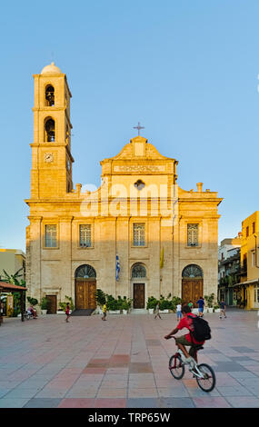 Creta, Grecia - 07/24/2009: ragazzo sulla bicicletta e bambini che giocano di fronte Cattedrale greco-ortodossa su Plateia Mitropoleos piazza chiamata Chiesa di th Foto Stock