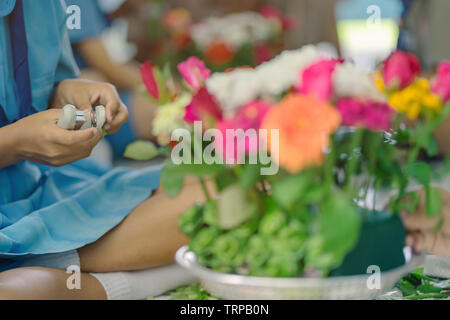 Gli studenti si aiutano a vicenda per creare un vassoio di fiori con il piedistallo per gli Insegnanti" Giorno Foto Stock