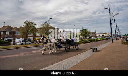 Turisti che si godono un cavallo e un giro in carrozza lungo il Golden Mile nella città costiera di Great Yarmouth, Norfolk Foto Stock