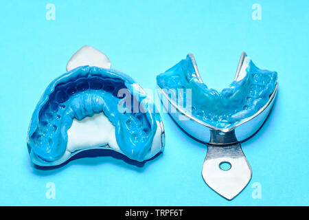 Due impronte dentali su uno sfondo blu. Dental stampi dai collimatori mobili superiore e inferiore di materiale siliconico. L impronta del dente fila di alta pre Foto Stock