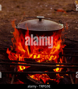 Il cibo nel calderone è preparato sul legno fuoco aperto in estate in natura nella versione Marching Band Foto Stock