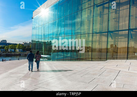 Oslo estate, vista posteriore in estate di un turista giovane discendente la grande rampa di accesso che conduce al tetto del Teatro dell'Opera di Oslo, Norvegia. Foto Stock